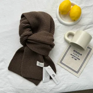 Vue en gros plan détaillée d'écharpe en tricot côtelé marron foncé avec texture douce.