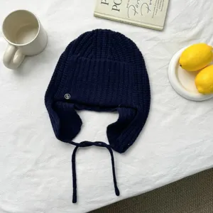 Cálido gorro de punto de lana azul oscuro con orejeras y cordones, ideal para otoño e invierno.