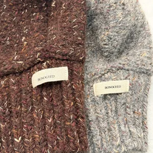 Flecked knit alpaca wool hooded scarf detail showing texture and brand label clearly.