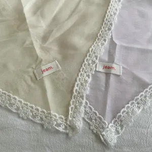 Close-up van effen kanten driehoekige hoofddoek met delicate witte kanten randdetails.