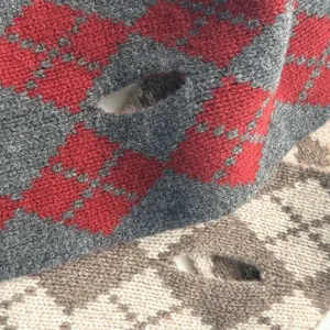 Gros plan détaillé de l'écharpe en tricot de laine douce avec une texture à motifs de losanges.