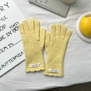 Guantes de punto amarillo con dedos separados, puños ondulados y etiqueta para invierno.