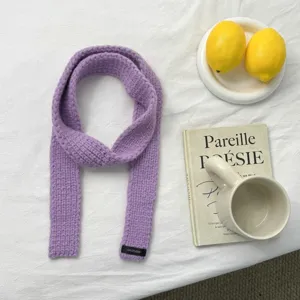 Cozy purple knit winter scarf with minimalist brand tag, narrow long design for warm daily wear.