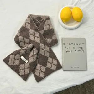 Vue de détail en gros plan de l'écharpe d'hiver en laine tricotée motif argyle beige.