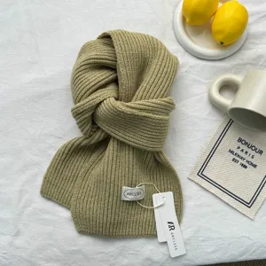 Gros plan sur l'écharpe en tricot vert olive, texture laine douce, détail plat confortable