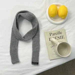 Detail view of a cozy grey knitted scarf, simple solid color winter warm accessory for daily wear.