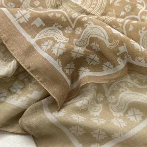 Close-up detail of cotton linen small square scarf with retro paisley print and fine stitched edge.
