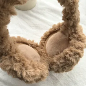 Gros plan sur les cache-oreilles d'hiver marron duveteux avec tissu en peluche douce et chaude.