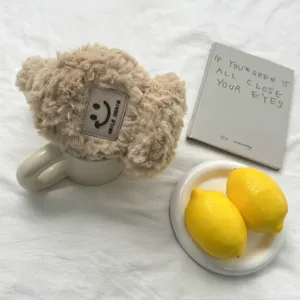 Détail de chauffe-oreilles d'hiver beiges et duveteux, texture peluche douce et joli design d'étiquette.