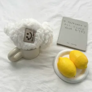 Vue de detail cache-oreilles blancs duveteux, chauffe-oreilles hiver en peluche.