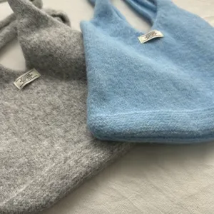 Détail de sac cabas en tricot de laine mélangée, texture douce, idéal pour le quotidien.