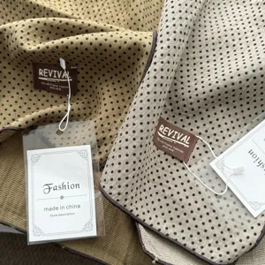 Gedetailleerde close-up met de textuur van de vintage stip katoenen sjaal en merklabels.