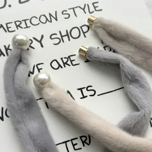 Plush magnetic scarf detail showing soft faux fur and elegant pearl clasp design.
