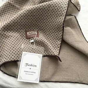 Gedetailleerd overzicht van een elegante stippensjaal, zachte stof met klassiek patroon voor stijl.