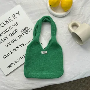 Vue détaillée d'un sac à main en tricot vert, gros plan sur le tissu du cabas en laine d'automne