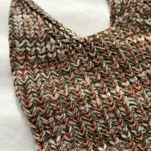 Nahaufnahme einer stilvollen, mehrfarbig gestrickten Handtasche mit feiner Wolltextur.