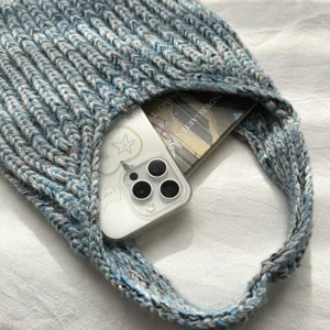 Nahaufnahme der farblich gemischten Strickhandtasche mit strukturierter Wolle und schickem Design.