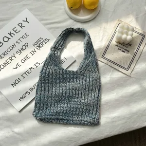 Nahaufnahme der blau melierten Stricktasche mit weicher Wollstruktur und rundem Griff.