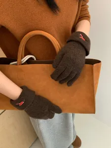 Detail view of winter warm brown knitted touchscreen gloves featuring cute puppy embroidery.