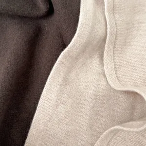 Soft wool knit scarf detail shot showing luxurious texture and dual-tone beige and brown fabric.