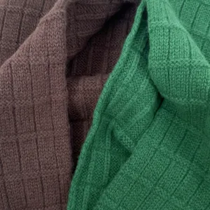 Close-up detail of soft woolen knitted scarf showing exquisite grid texture and warm quality.