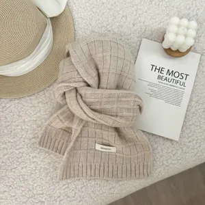 Beige knitted wool scarf with classic grid pattern, soft and warm winter neck warmer detail.