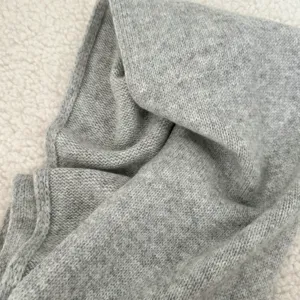 Close-up detail of soft grey knit winter scarf, cozy texture for cold weather.