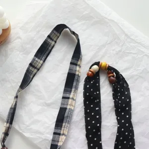 Close-up detail of polka dot beaded fabric scarf necklace, showcasing unique wooden bead accents.