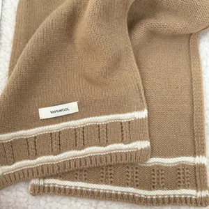 Cozy wool knitted scarf detail with warm camel tone and classic stripes for winter style.