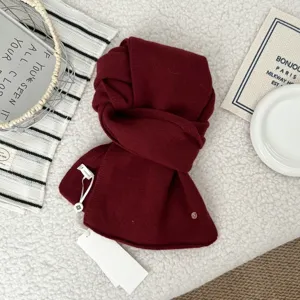 Detailed view of a cozy burgundy knitted wool winter scarf, soft texture and warm neck wrap style.