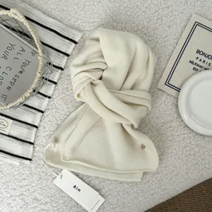 Cozy cream white knit scarf for women, thick winter warm neck wrap with stylish tag design.