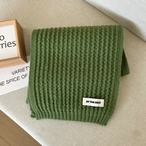 Close-up detail of green knitted winter scarf, soft texture and simple daily warm neckerchief.