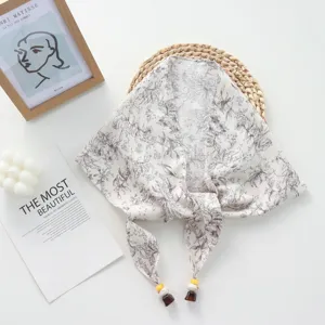 Detail view of vintage floral tie-up triangular scarf, textured fabric with beaded string.