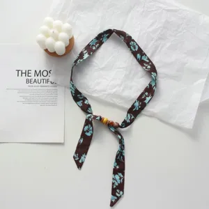 Detailed view of the brown floral fabric ribbon scarf with wooden beads, showcasing texture.