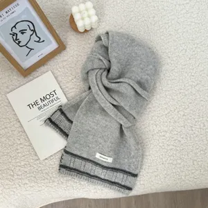 Cozy grey wool knitted winter scarf with classic stripes and minimalist style label for women.
