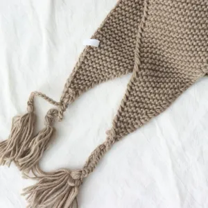 Gebreide franje driehoek sjaal detail, chique khaki gebreide cape en mode accessoire.