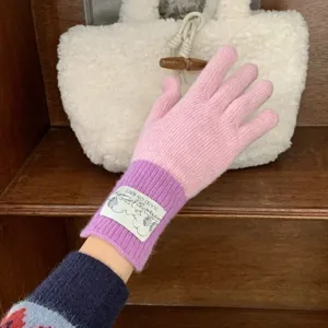 Detail view of pink and purple color-block knit gloves featuring a cute wrist label.