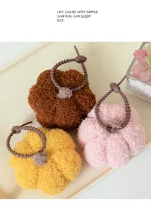 Primo piano dettagliato di simpatici portachiavi di peluche a zucca su un vassoio.