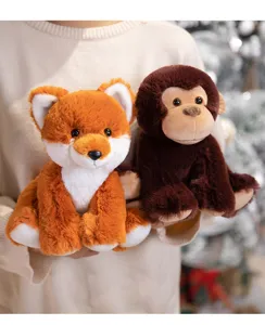 Detail shot of cute plush fox and monkey toys held in hands, soft and fluffy fabric.