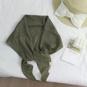 Nahaufnahme des retro grünen Karomuster Rautenhalstuchs, elegante Flat-Lay-Deko.