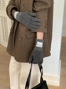 Close-up detail of cozy grey knit gloves with chic cuffs, soft texture for winter warmth.