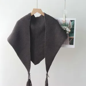Details van gebreide driehoekige sjaal, donkerbruine franje omslagdoek, modieus accessoire.