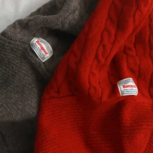 Vue détaillée de la cagoule tricotée épaisse bonnet d'hiver chaud en rouge et gris.
