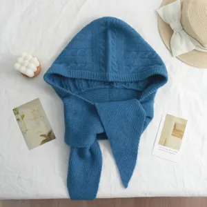 Gros plan sur une cagoule écharpe en tricot bleu avec texture torsadée, douce et chaude.