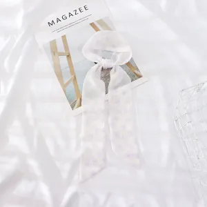 Dettaglio sciarpa nastro in chiffon floreale, elegante motivo a piccoli fiori viola chic.