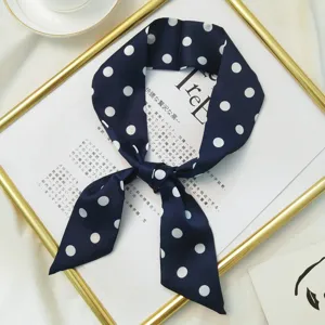 Detail view of navy blue polka dot skinny scarf, elegant silk twilly ribbon for bags hair and head deco.