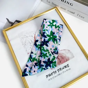 Vue détaillée du foulard en soie floral, élégant cache-col bleu pour sacs et poignets.