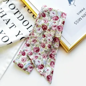 Détail de foulard twilly imprimé floral, motif de rose vintage pour sac et cou.