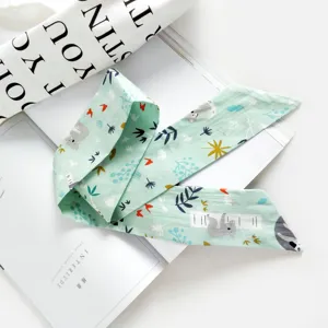 Gros plan détaillé d'un foulard étroit en coton et lin vert clair avec motif koala.