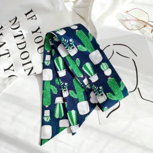 Detail foulard etroit imprime cactus, ruban en soie bleu marine pour sac ou poignet.